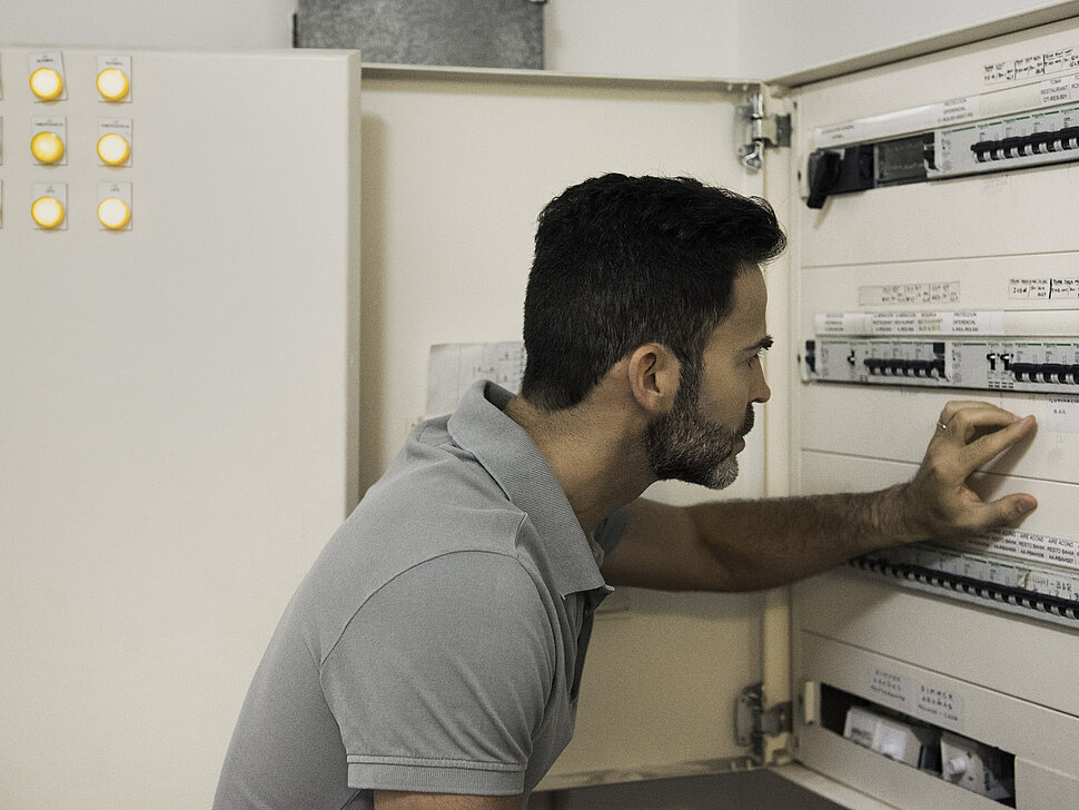 Elektriker überprüft elektrischen Schaltschrank